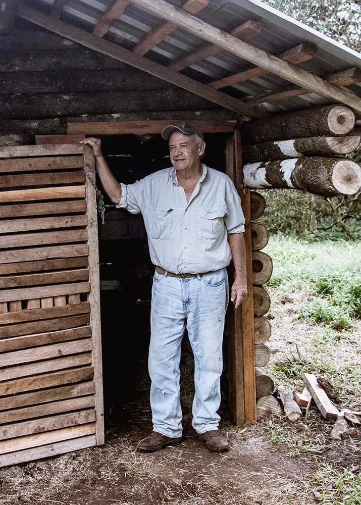Rodrigo Jácome en la puerta de una cabaña de madera en la finca