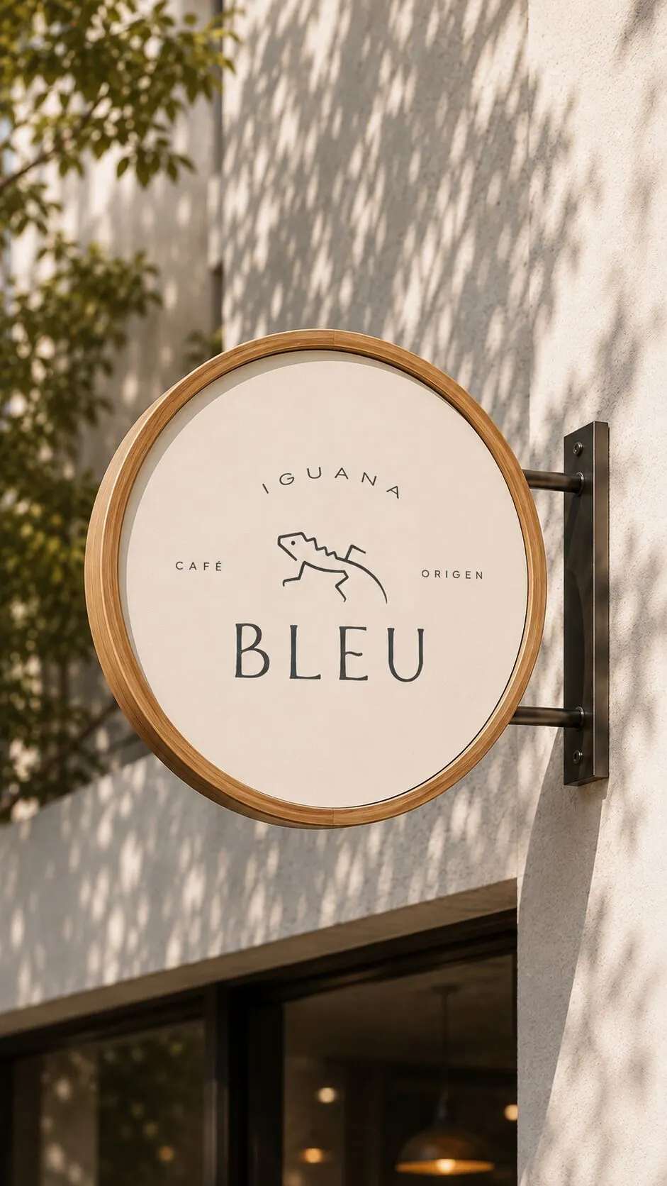 Letrero colgante redondo de Iguana Bleu en una fachada blanca